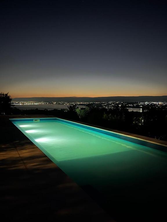a large swimming pool with green lighting at night at Complejo DOS LUNAS in San Roque