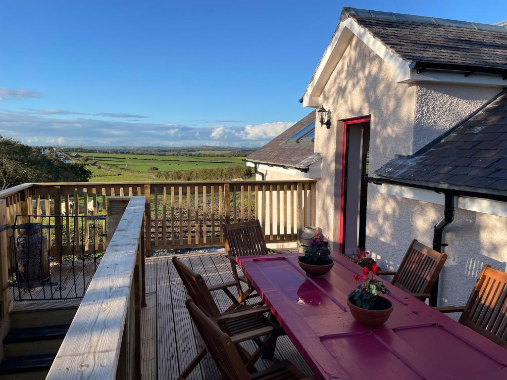 a wooden deck with a table and chairs on it at West Coast Whistlestop in Ochiltree