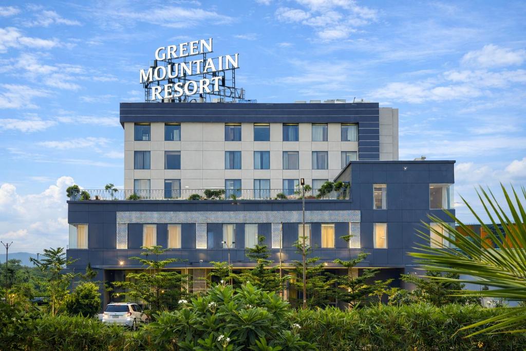 a building with a sign on the top of it at Green Mountain Resort in Guna