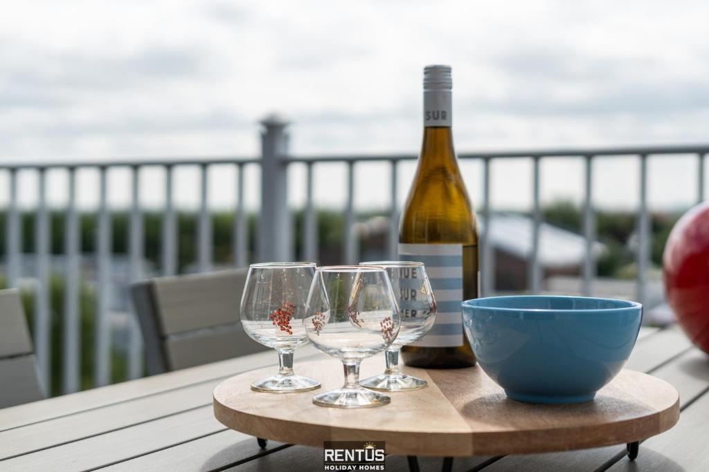 a bottle of wine and two wine glasses on a table at Maison Beluga - spacious apartment in Westende in Middelkerke