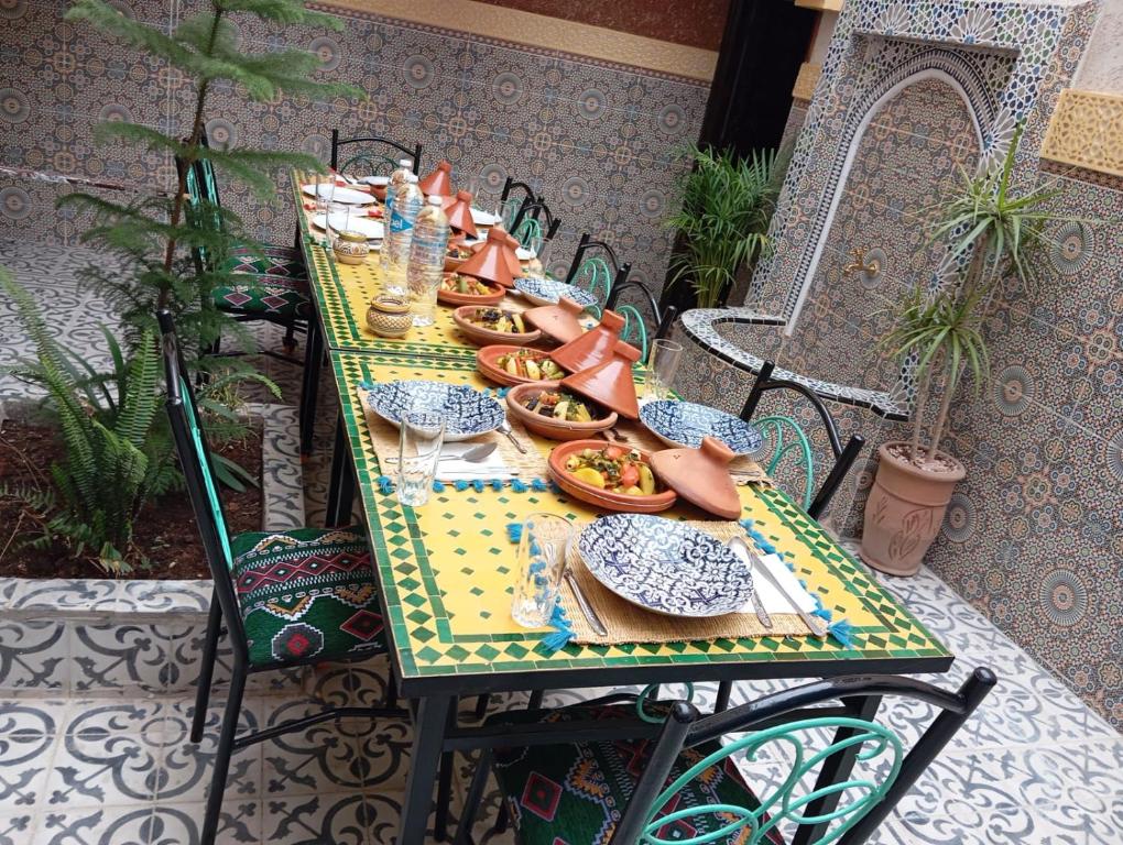 a long table with plates of food on it at Riad Ingbiwn N'Tiznit in Tiznit