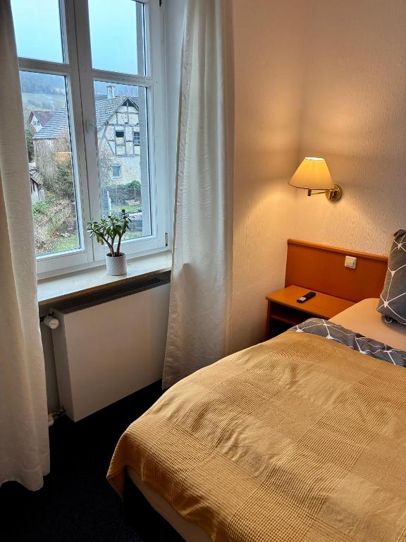 a bedroom with a bed and a window at Restaurant Rebea in Sulzburg