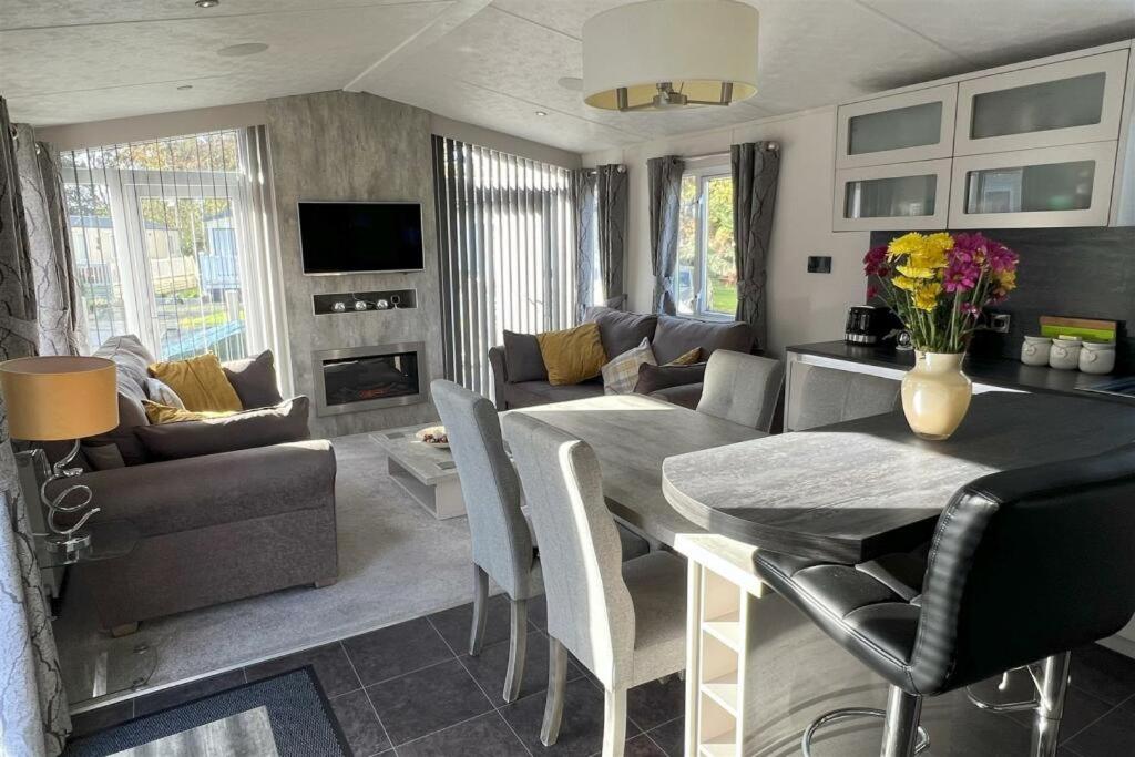 a living room with a table and a living room with a couch at Poppy in Ferndown