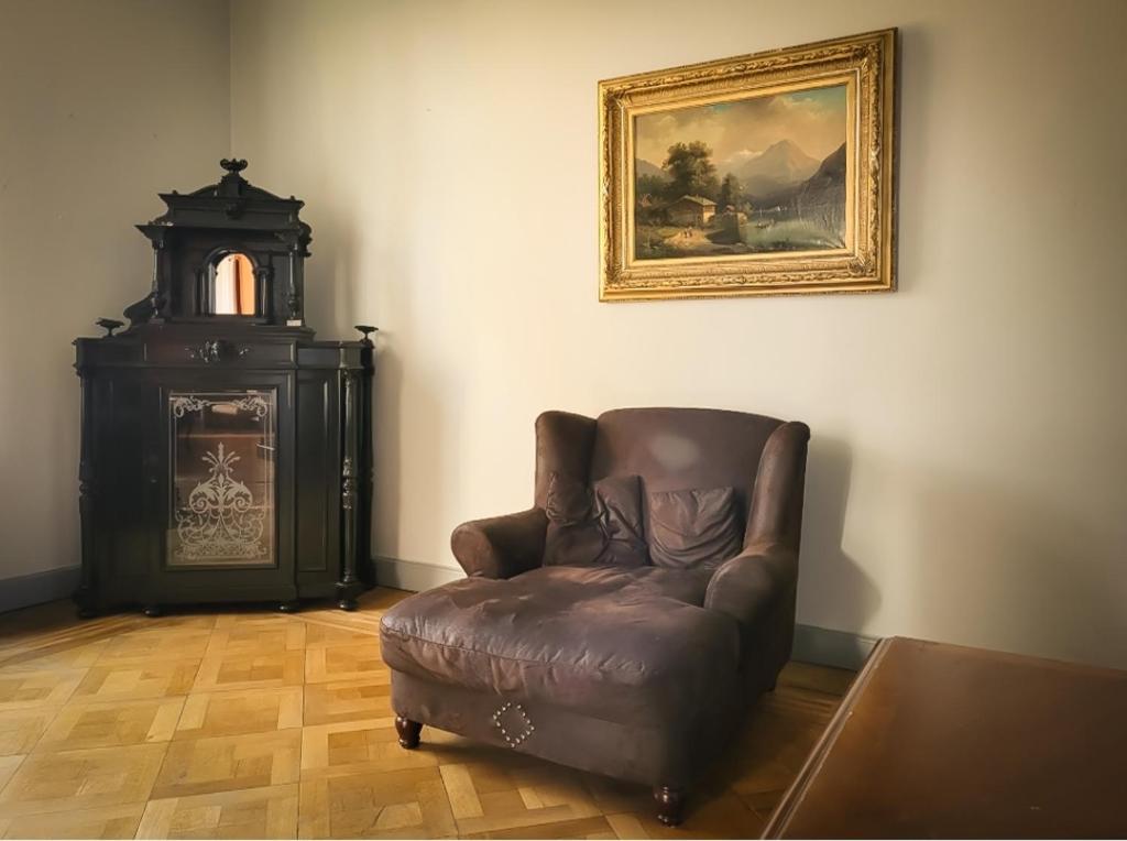a living room with a leather chair and a painting at Villa Dietel Greiz in Greiz