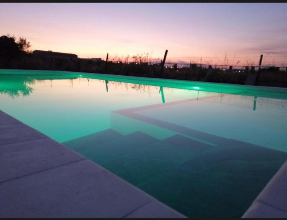a pool of water with a sunset in the background at Villa Marzamemi in Marzamemi