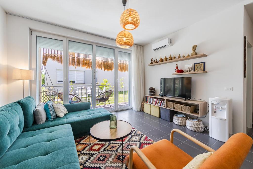 a living room with a couch and a tv at Talea Joyful Stay by PikHost in Lezhë