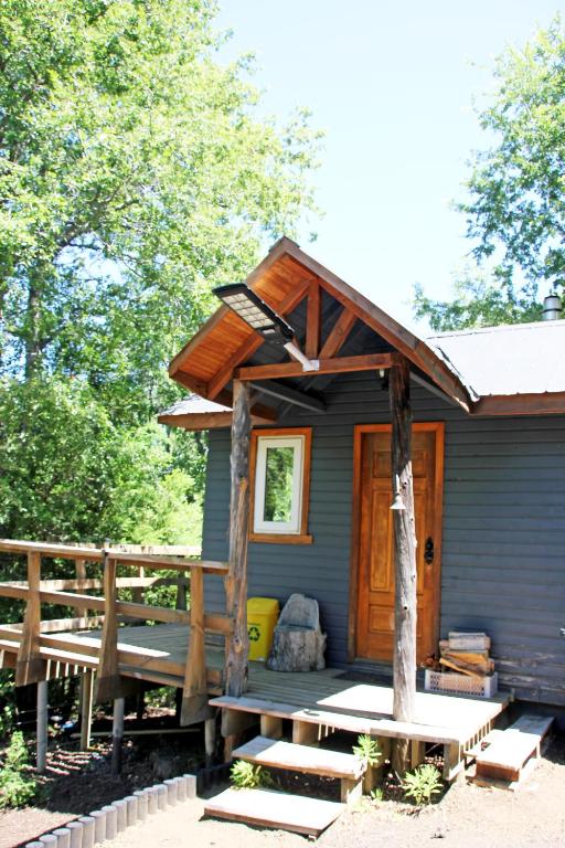 a blue house with a porch and a porch swing at Cabaña Fio-Fio Conguillio National Park in Conguillío
