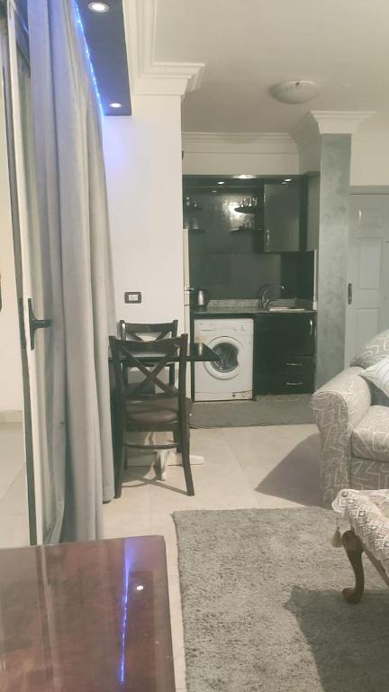 a living room with a table and a chair and a kitchen at Sharm life 106 in Sharm El Sheikh