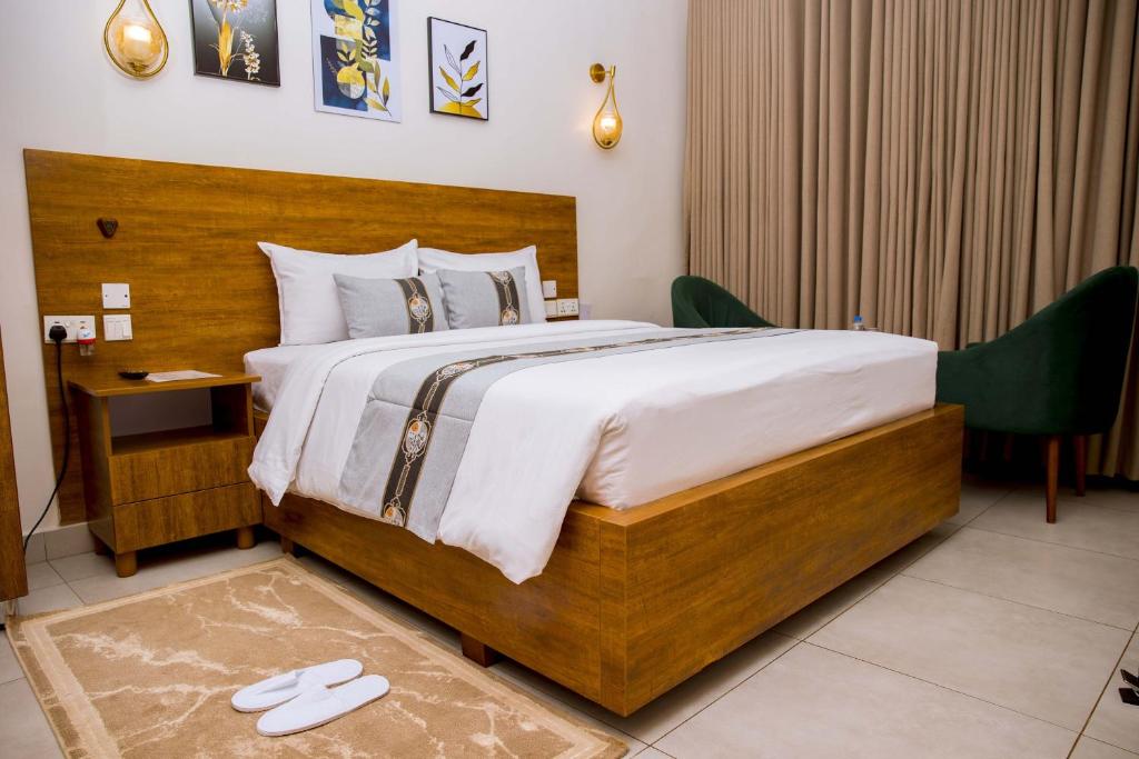 a bedroom with a large bed with a wooden headboard at Velvet Suites in Kigali