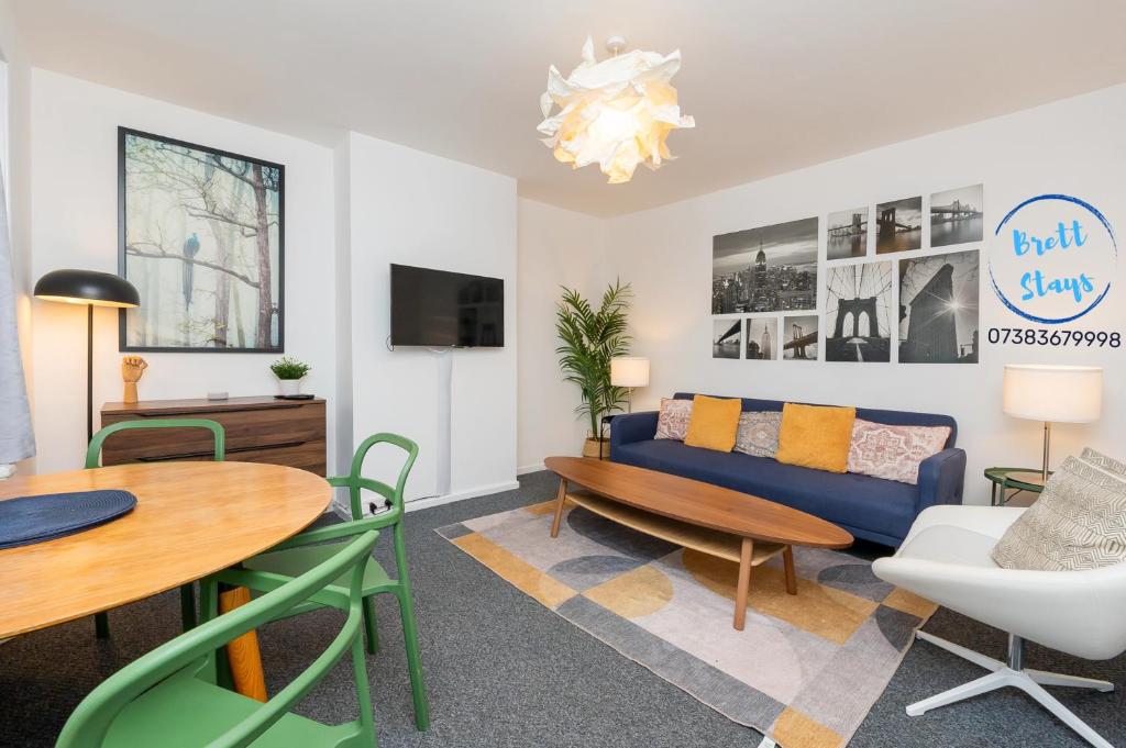 a living room with a blue couch and a table at Contractor Base Avonmouth 4 Bed Sleeps 7 Van Parking in Avonmouth
