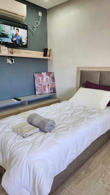 a bedroom with a white bed with a tv on the wall at freehome oujda in Oujda