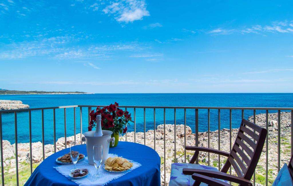 a table with a blue table cloth on a balcony with the ocean at Cielo Mar in S'Illot