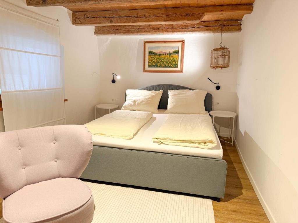 a small bedroom with a bed and a chair at Holy View Apartment in Bolzano
