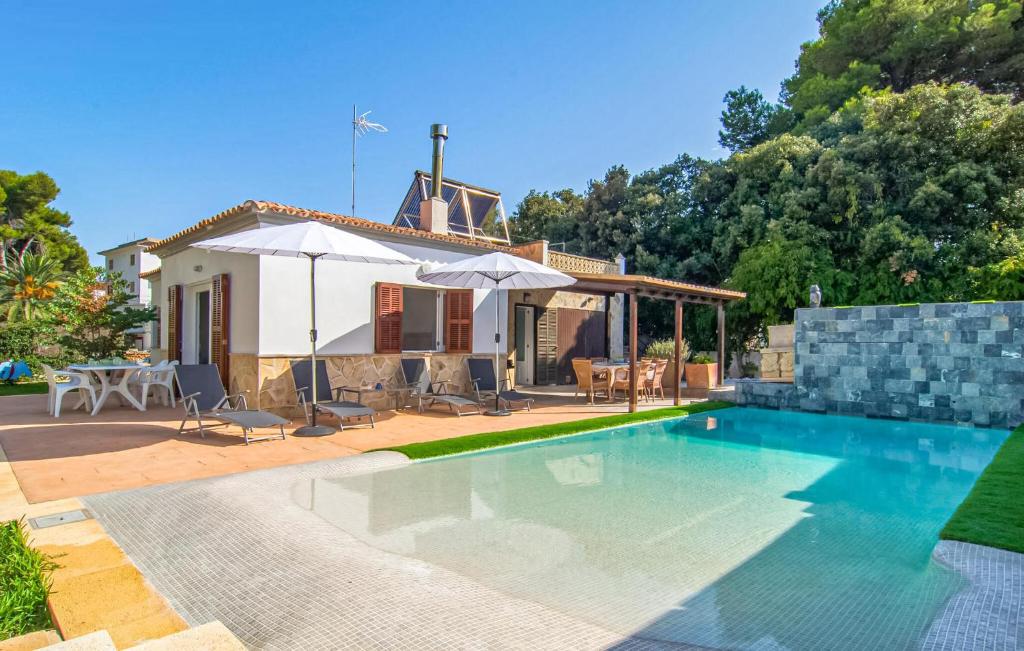 a villa with a swimming pool in front of a house at Sa Gola in Canyamel