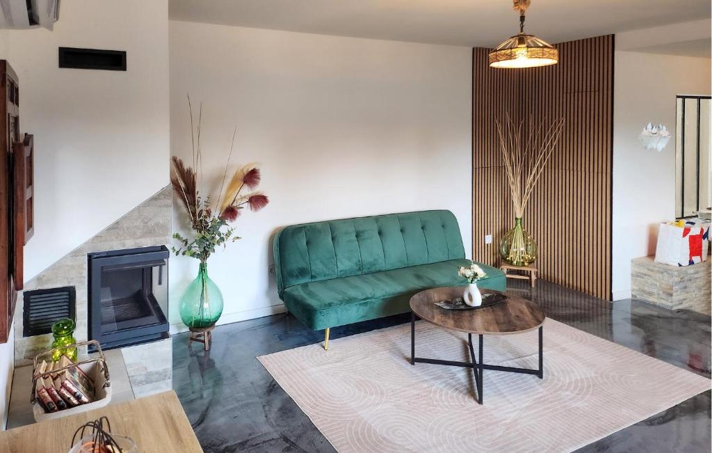 a living room with a green couch and a table at Bel Appartement Reposant in Rambervillers