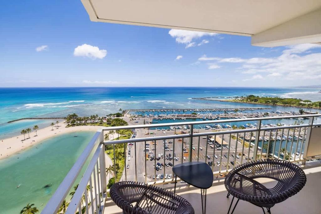 a balcony with chairs and a view of the beach at #Marbella Lane - Luxe 2BR with Panoramic Ocean View in Honolulu