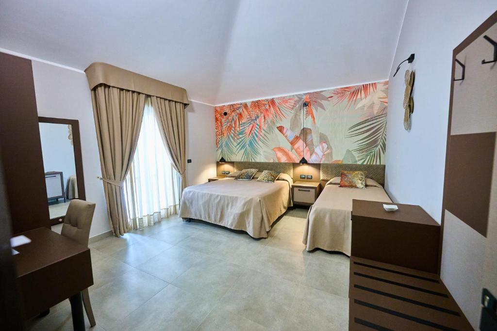 a bedroom with two beds and a painting on the wall at Le 2 Palme Apartments in Catanzaro Lido
