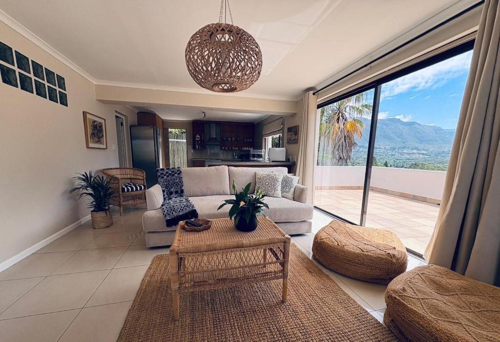 a living room with a couch and a table at Spacious sunny secure and central with scenic views in Hout Bay