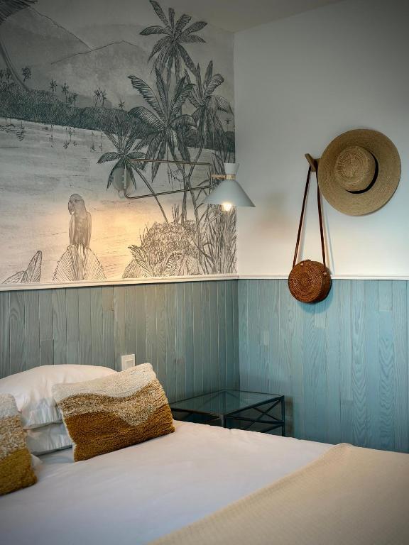 a bedroom with a bed with a painting on the wall at Le Pressoir de la Gervaiserie - 300m de la plage in Réville