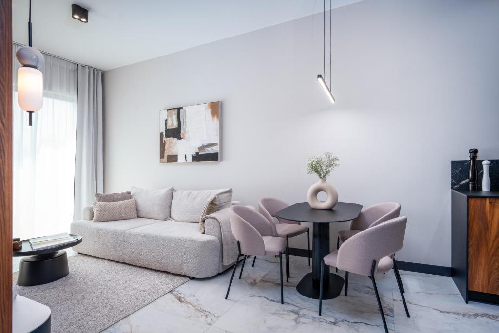 a living room with a couch and a table and chairs at Nad Zatoką Apartament 132 by Warmia4Rent, przy samej plaży miejskiej in Olsztyn