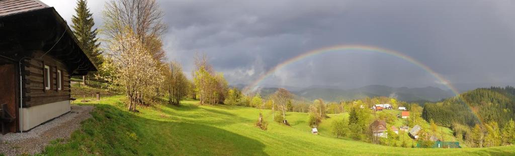 a rainbow over a green field with a house at PANORAMA RANČ in Ježíci