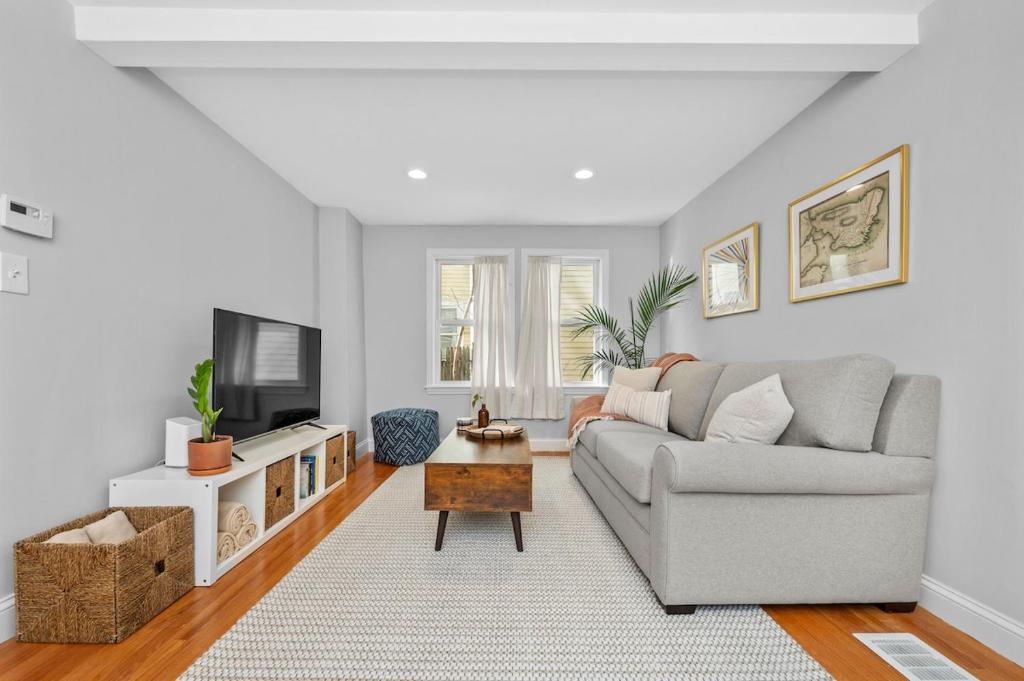 a living room with a couch and a tv at Boston Condo With FREE Parking in Boston