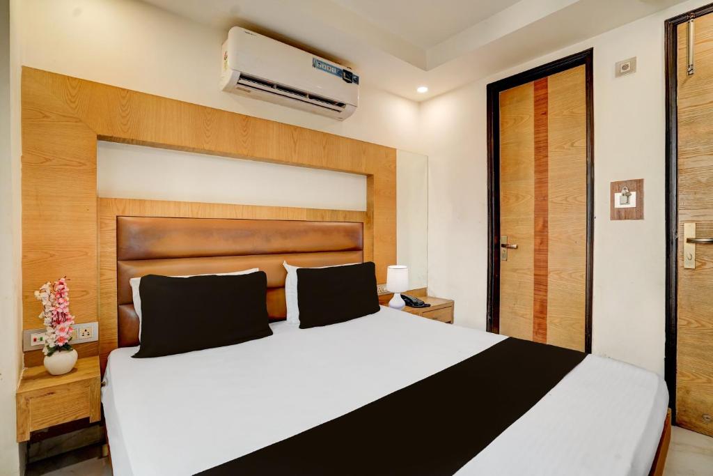a bedroom with a large white bed with a wooden headboard at Istay By A1Rooms in Jāmb
