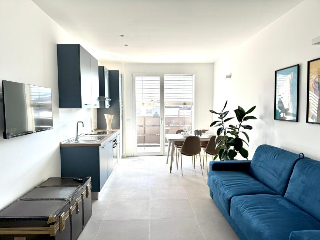 a living room with a blue couch and a kitchen at Jungle - Sarnico Color Suites in Sarnico