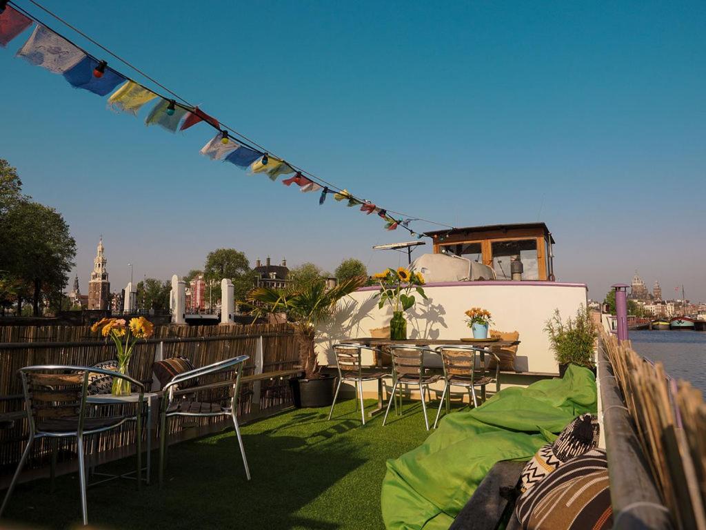 a deck with a table and chairs and a boat at FLOW in Amsterdam