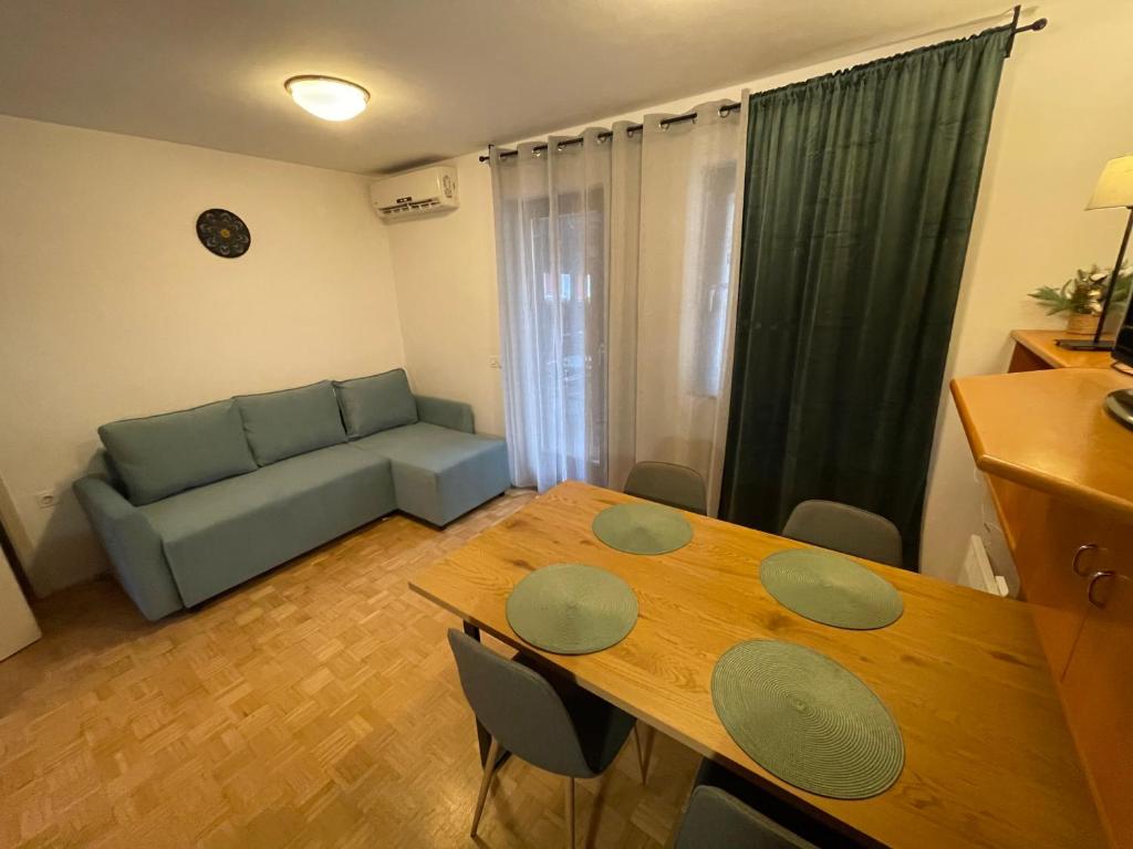 a living room with a table and a couch at Terme Čatež apartma Solist in Mihalovec