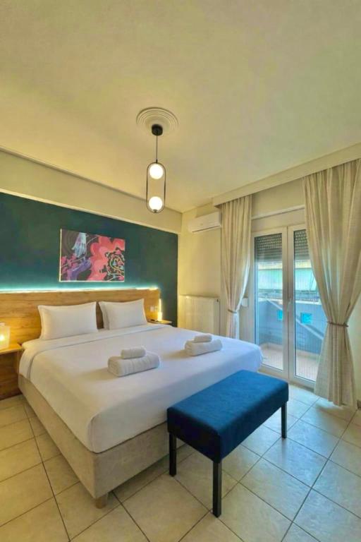 a bedroom with a large white bed and a blue bench at Central appartment 2 with parking in Larisa