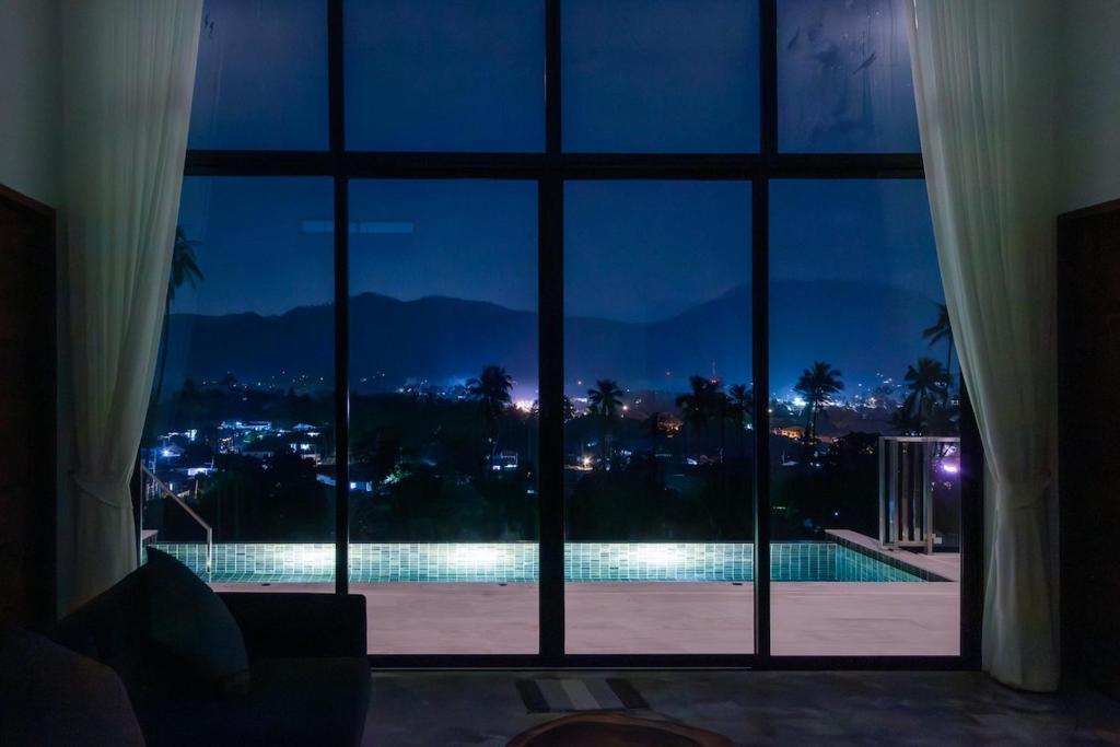 a view of a swimming pool seen through a window at Panorama View Villa in Ban Thung