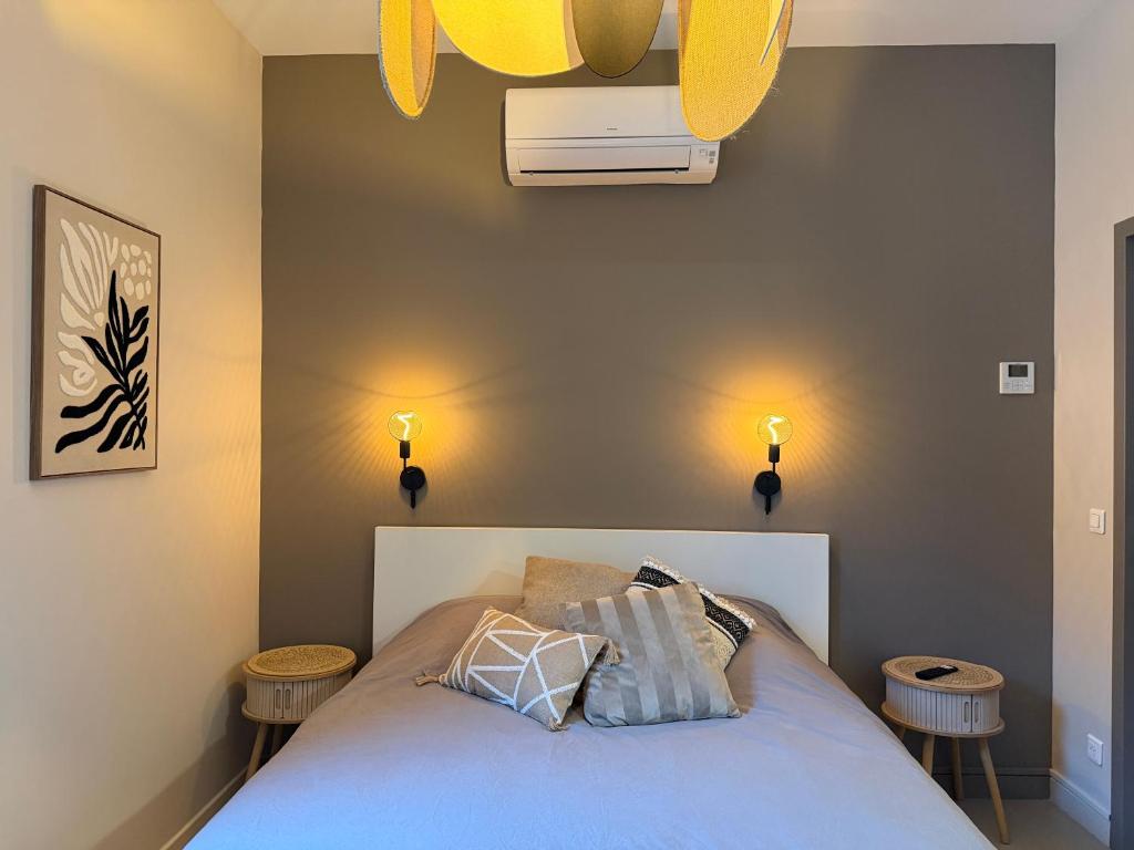 a bedroom with a bed with blue sheets and two tables at Les Terrasses du Rhône, Baix in Baix