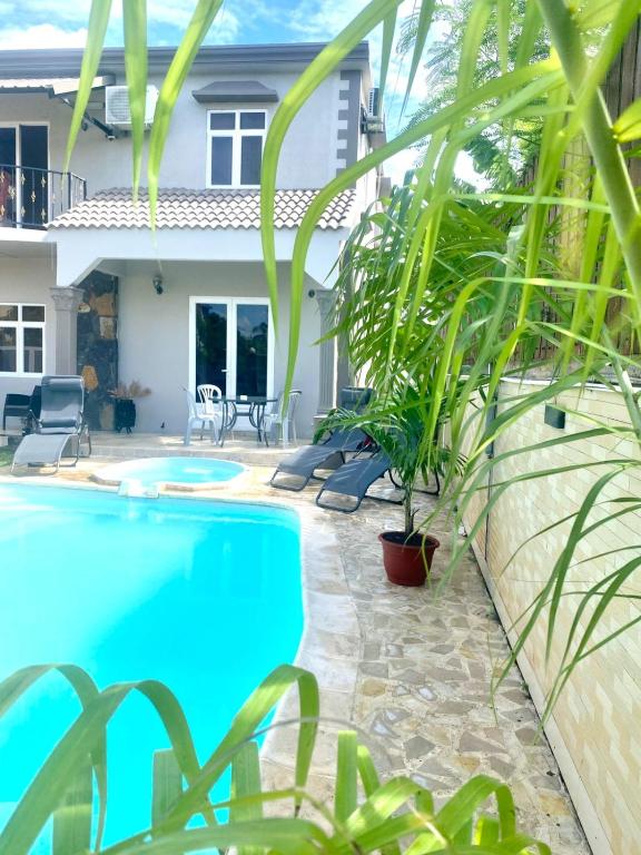 a pool in front of a house with plants at Appartement first floor in Trou aux Biches