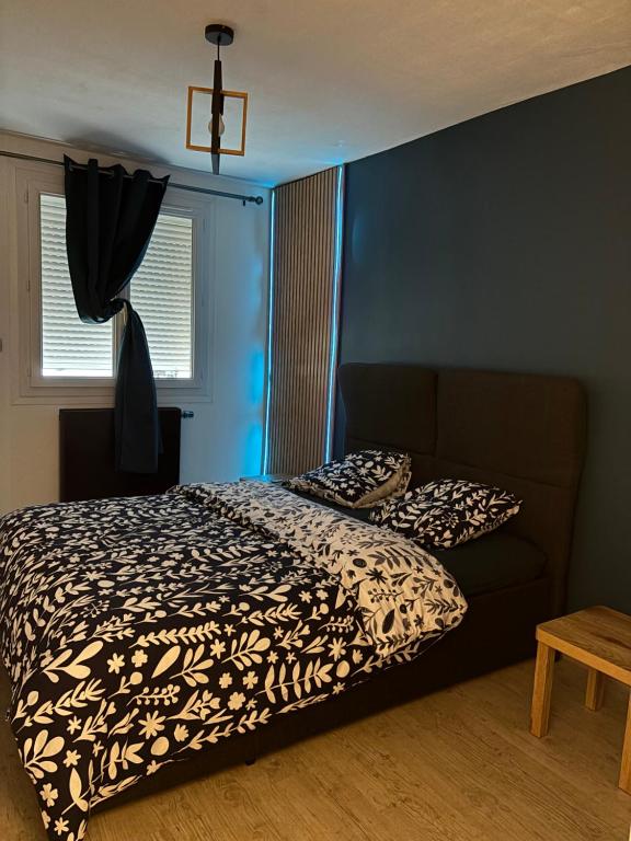 a bedroom with a bed and a couch with pillows at Le Cocon Nîmois in Nîmes
