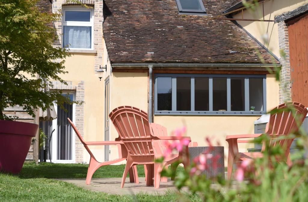 two chairs and a table in front of a house at Au logis de Bayard in Vareilles
