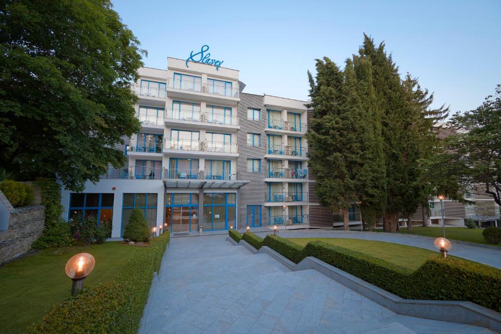 a large building with a pathway in front of it at Hotel Slavey - All Inclusive in Golden Sands