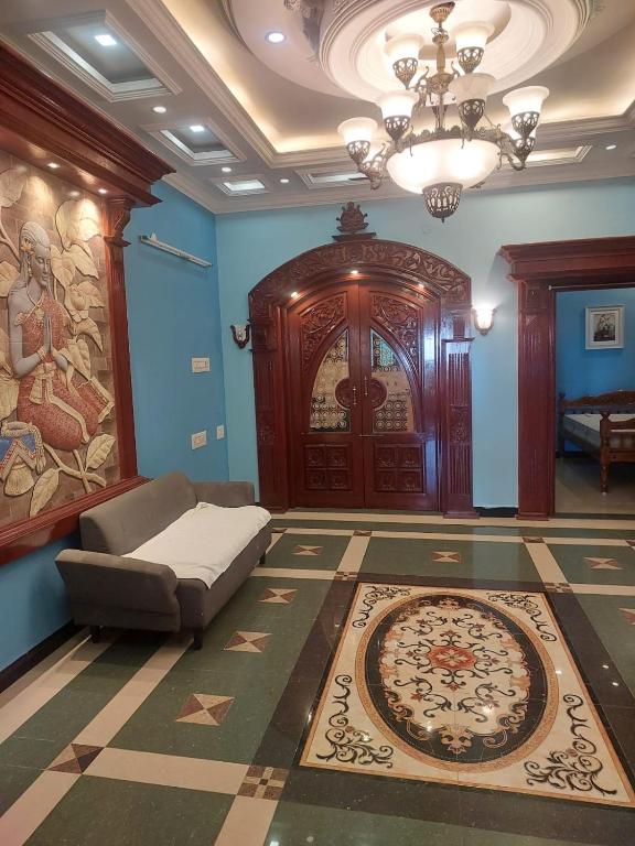 a living room with a couch and a large wooden door at Unique Stays in Pondicherry