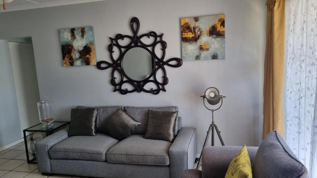 a living room with a couch and a mirror at Riley's Place in Cape Town