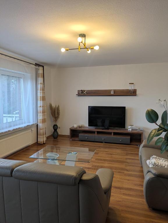 a living room with a couch and a flat screen tv at Schöne, große Wohnung mit 3 Betten in Bramsche