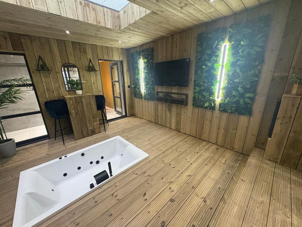 a large bath tub in a room with wooden floors at Willow Lodge in Ringwood