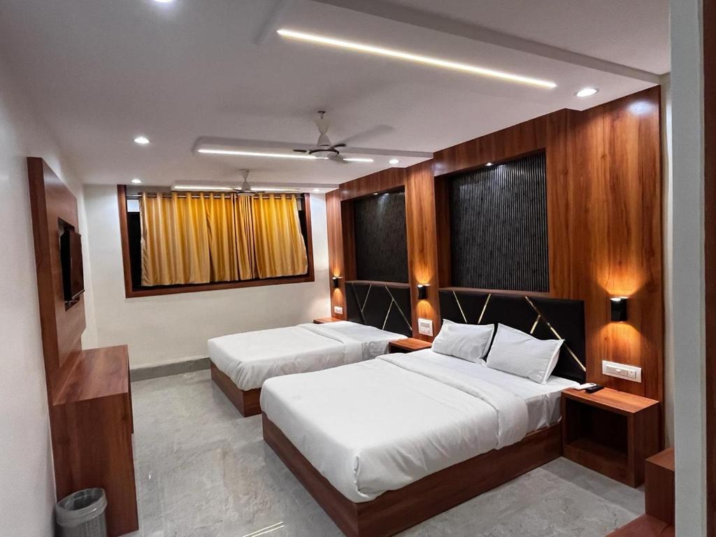 a hotel room with two beds and a television at Hotel Avion Park Executive in Mumbai