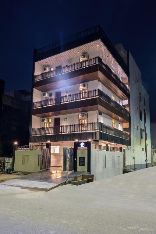 a tall building with a parking lot in front of it at Hotel Park Tree I Sec-63A I Noida I Couple Friendly and Corporate Rooms available in Noida