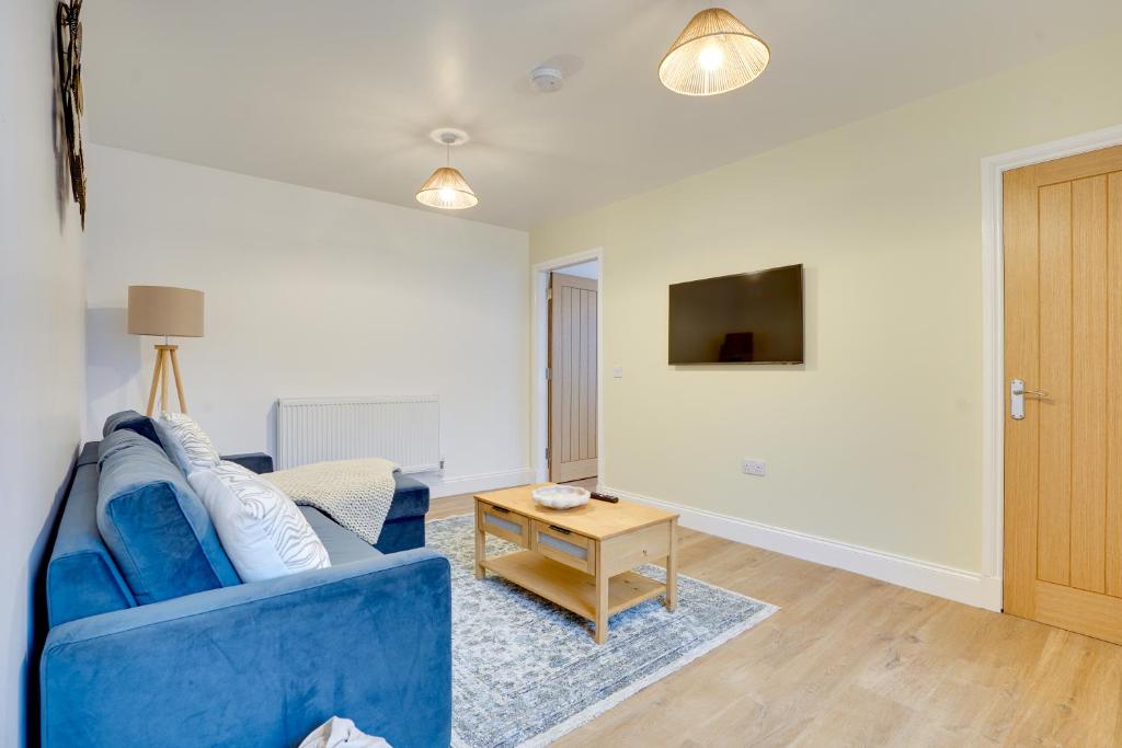 a living room with a blue couch and a table at Apt 2 Armatage Flats, Eyemouth in Eyemouth