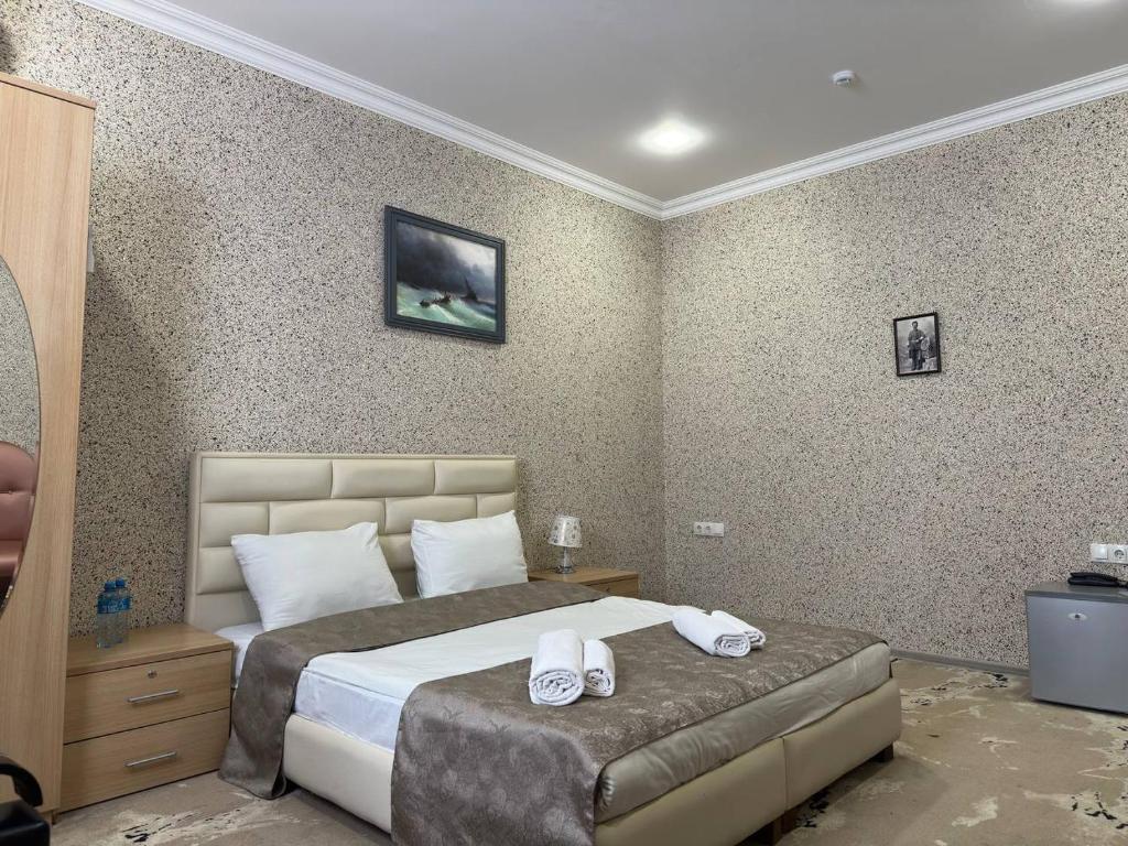 a bedroom with a bed with two towels on it at Aquapark Quba Hotel in Quba