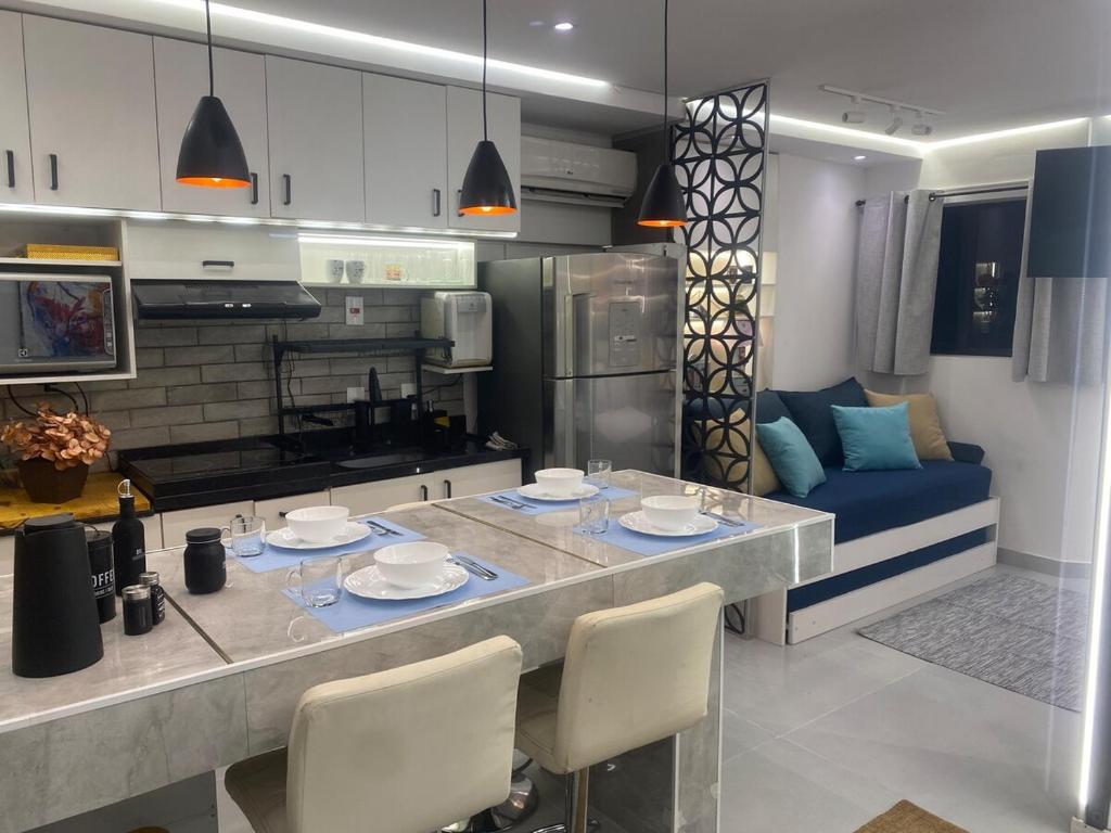 a kitchen with a table with chairs and a couch at Studio Arte de Cuidar in Campinas