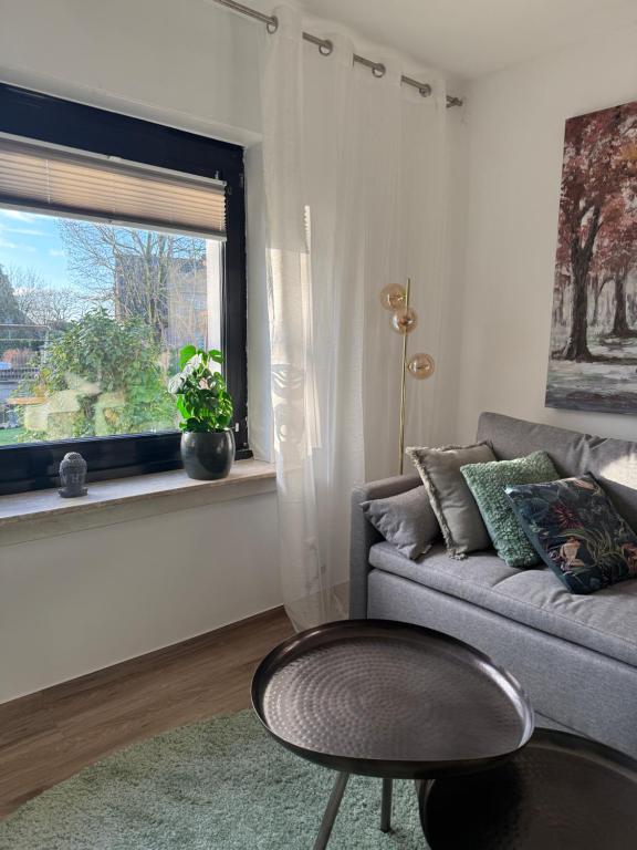 a living room with a couch and a table and a window at Q80 Appartement in Schermbeck