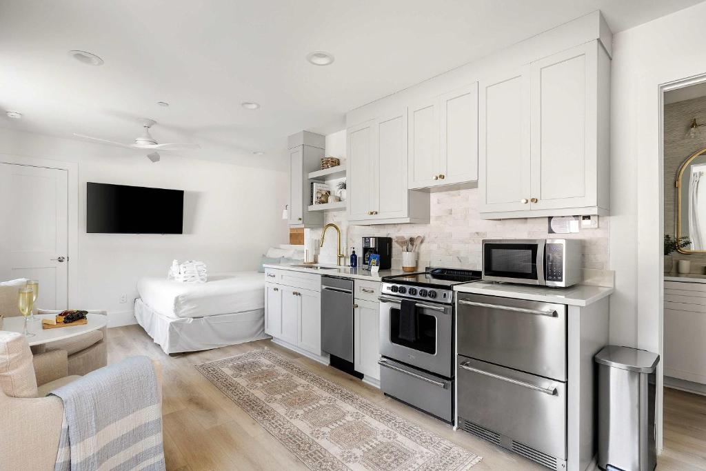 a kitchen with stainless steel appliances and a living room at The Sumter 1bd Condo 1 Block to Ocean in Folly Beach