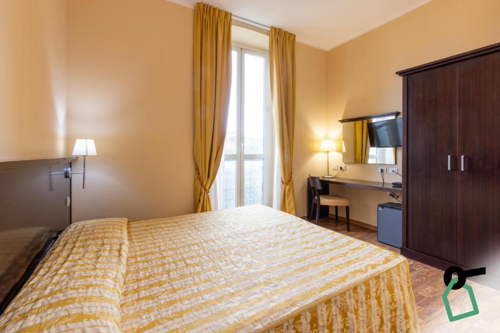 a hotel room with a bed and a desk at Hotiday Cagliari Lungomare in Cagliari