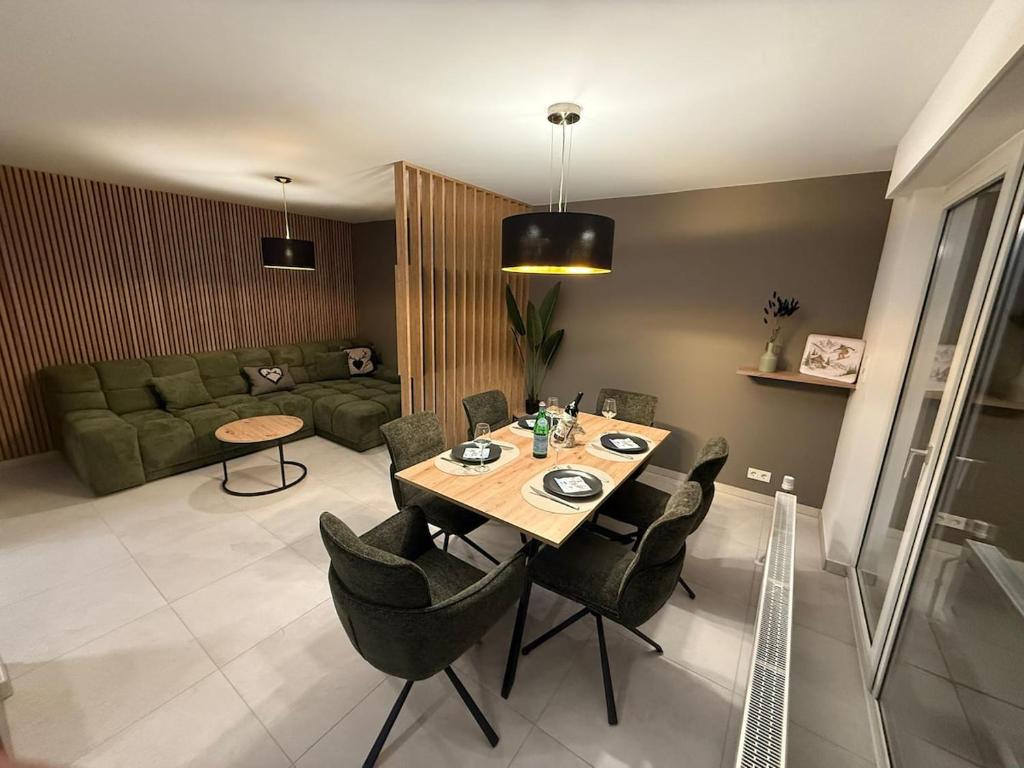 a living room with a table and chairs and a couch at Mountain Lodge - Design Apartment in Winterberg